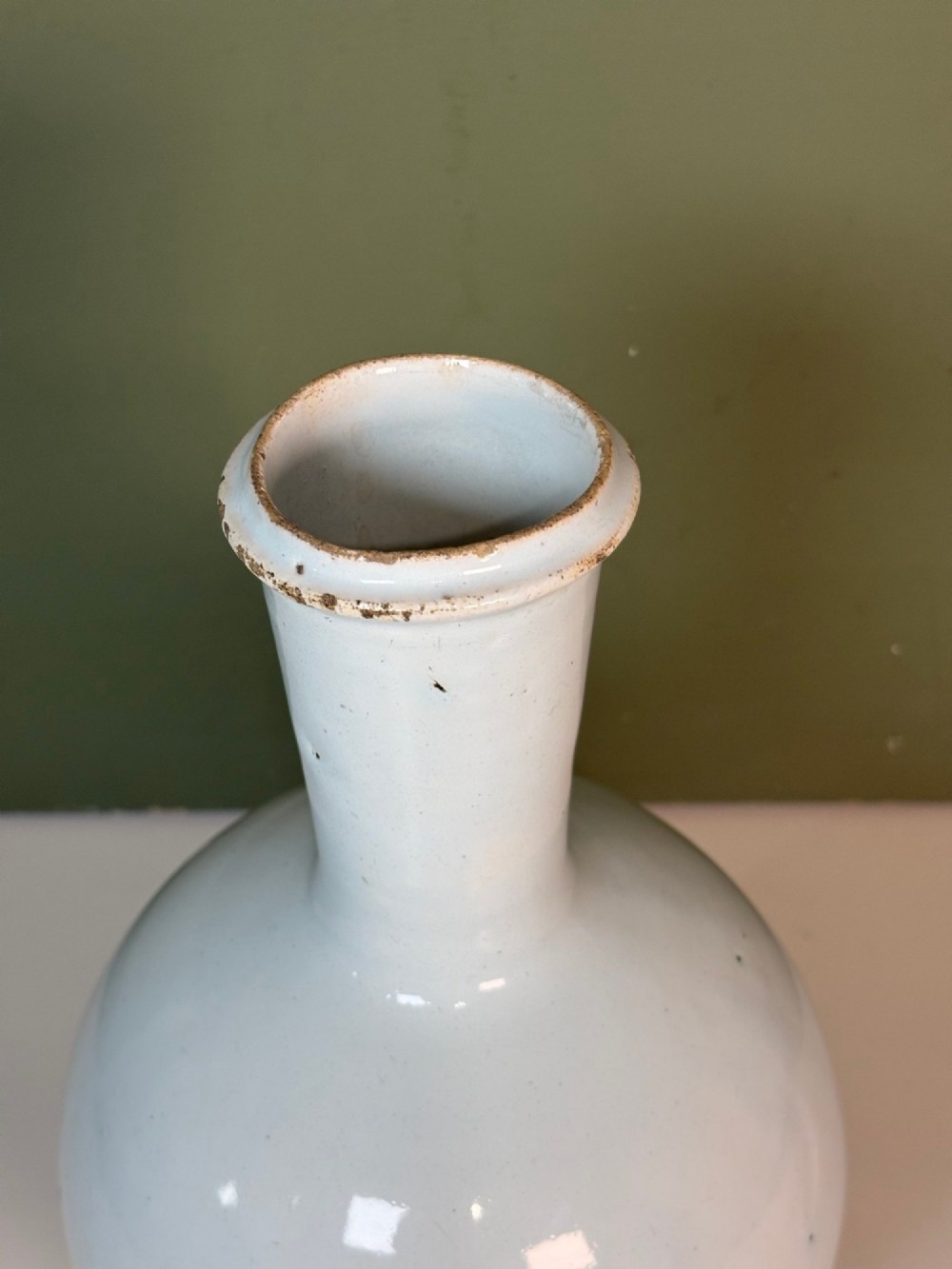 An 18th-century tin-glazed earthenware Delft apothecary bottle decorated with a hand-painted blue cartouche, peacocks, and Latin inscription. View IV