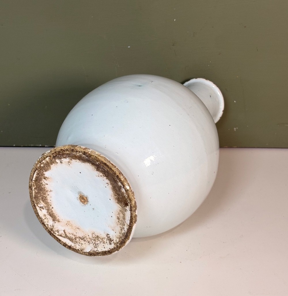 An 18th-century tin-glazed earthenware Delft apothecary bottle decorated with a hand-painted blue cartouche, peacocks, and Latin inscription. View V