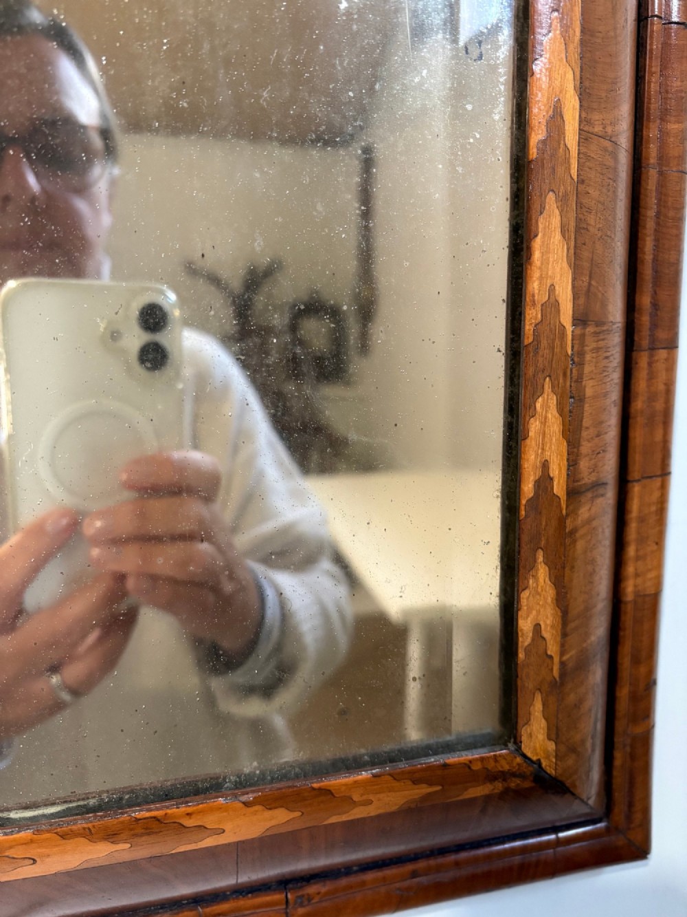 An 18th-century rectangular wall mirror featuring a cushion-moulded walnut frame with crossgrain veneers and herringbone inlay surrounding an aged reflective glass plate. View IV
