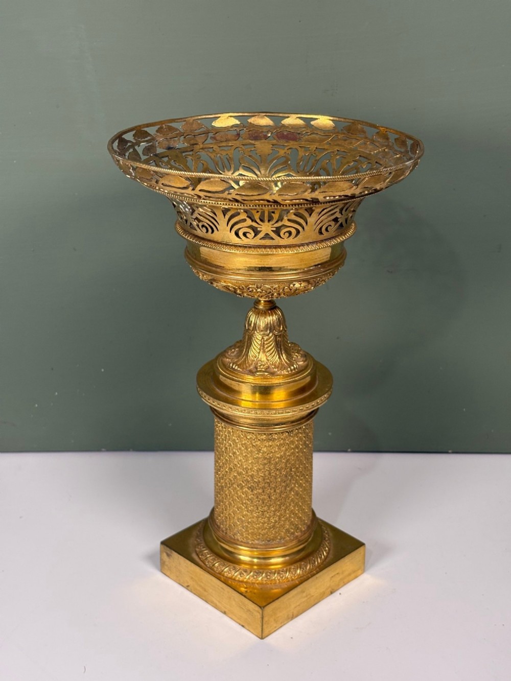 An early 19th-century gilt bronze ormolu vase featuring a pierced filigree flared rim, leaf-moulded bowl, textured pedestal column, and square base. View III