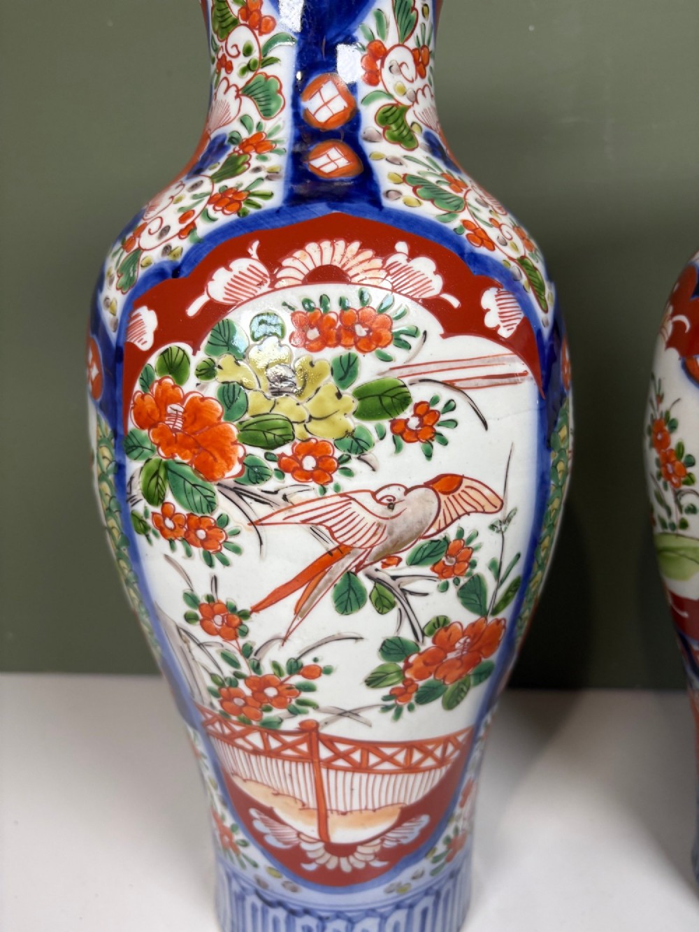 A matching pair of nineteenth-century Japanese Imari porcelain vases featuring hand-painted floral panels, bird motifs, and intricate cobalt blue and iron-red geometric patterns. View IV