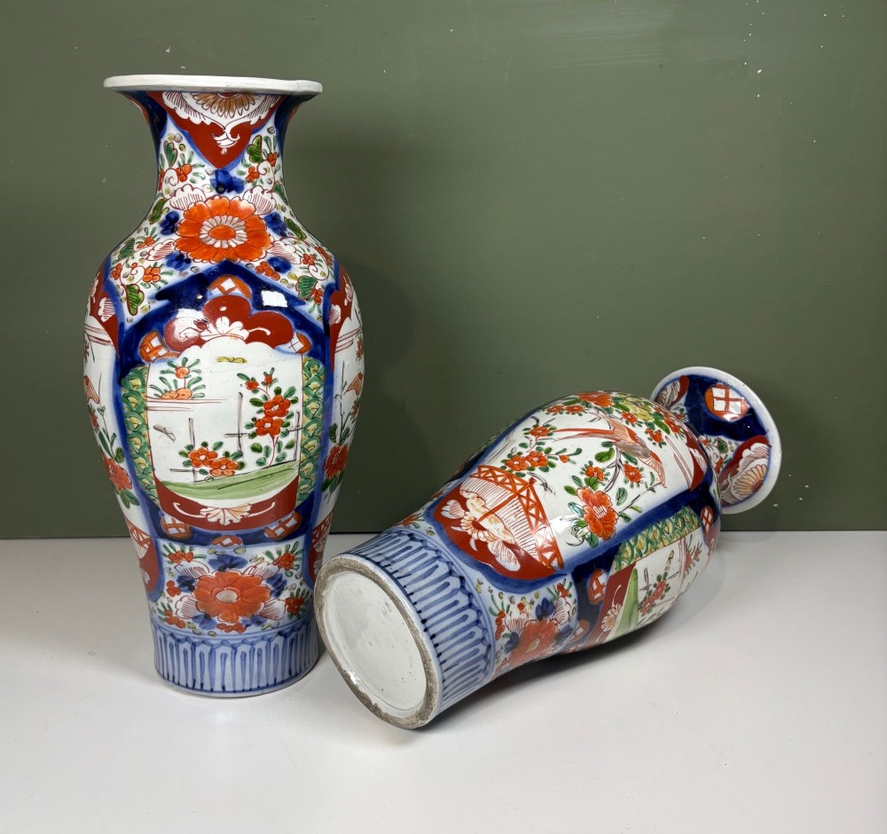A matching pair of nineteenth-century Japanese Imari porcelain vases featuring hand-painted floral panels, bird motifs, and intricate cobalt blue and iron-red geometric patterns. View VI