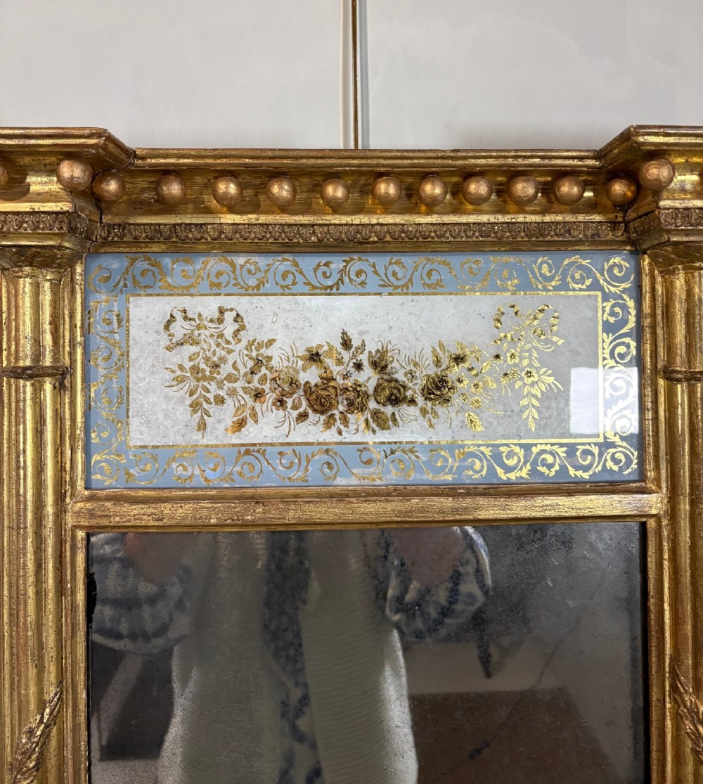A vertical Regency giltwood pier mirror with fluted side columns, ball-ornamented cornice, and a decorative floral verre eglomise glass panel. View III