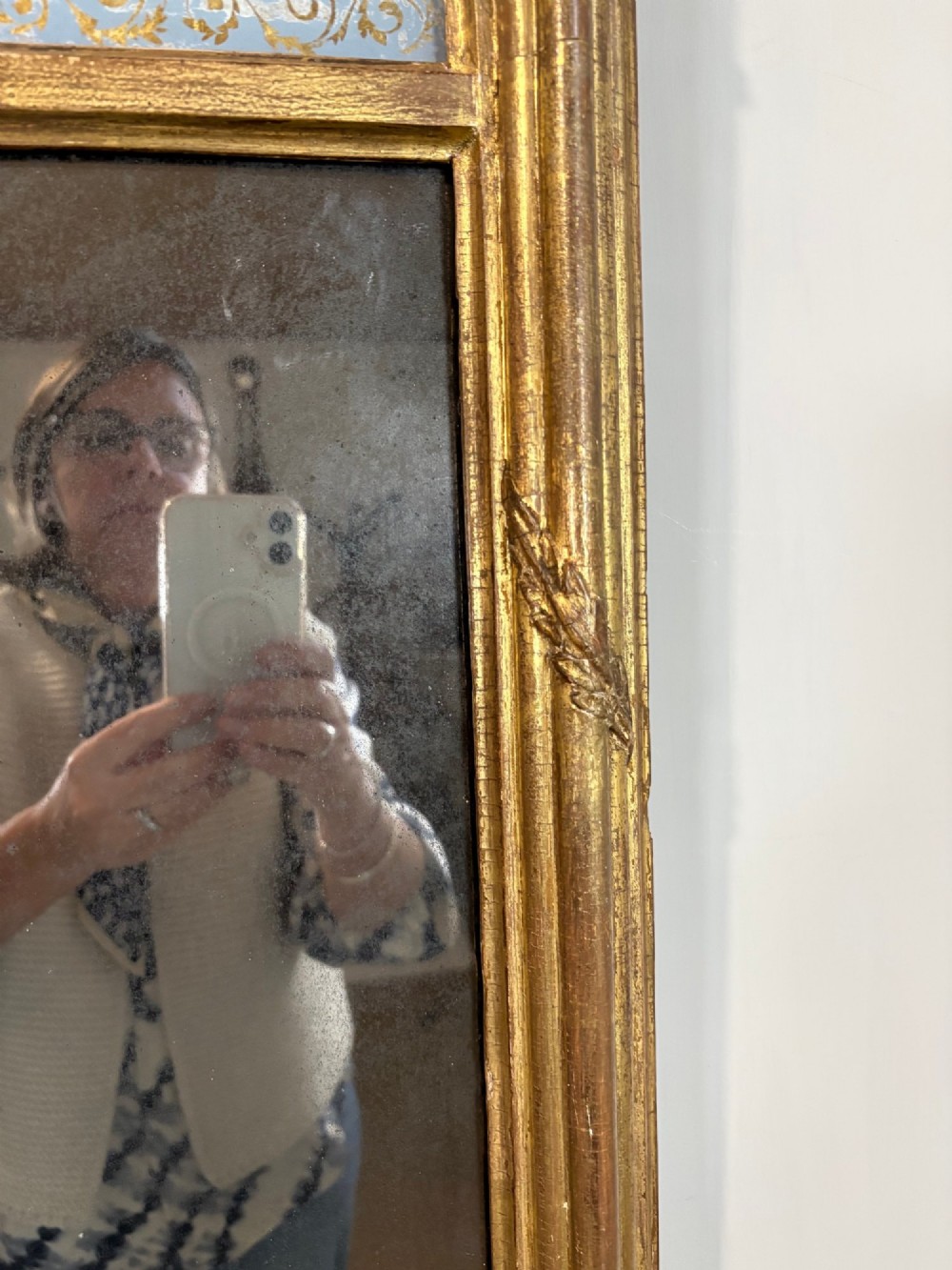 A vertical Regency giltwood pier mirror with fluted side columns, ball-ornamented cornice, and a decorative floral verre eglomise glass panel. View VI