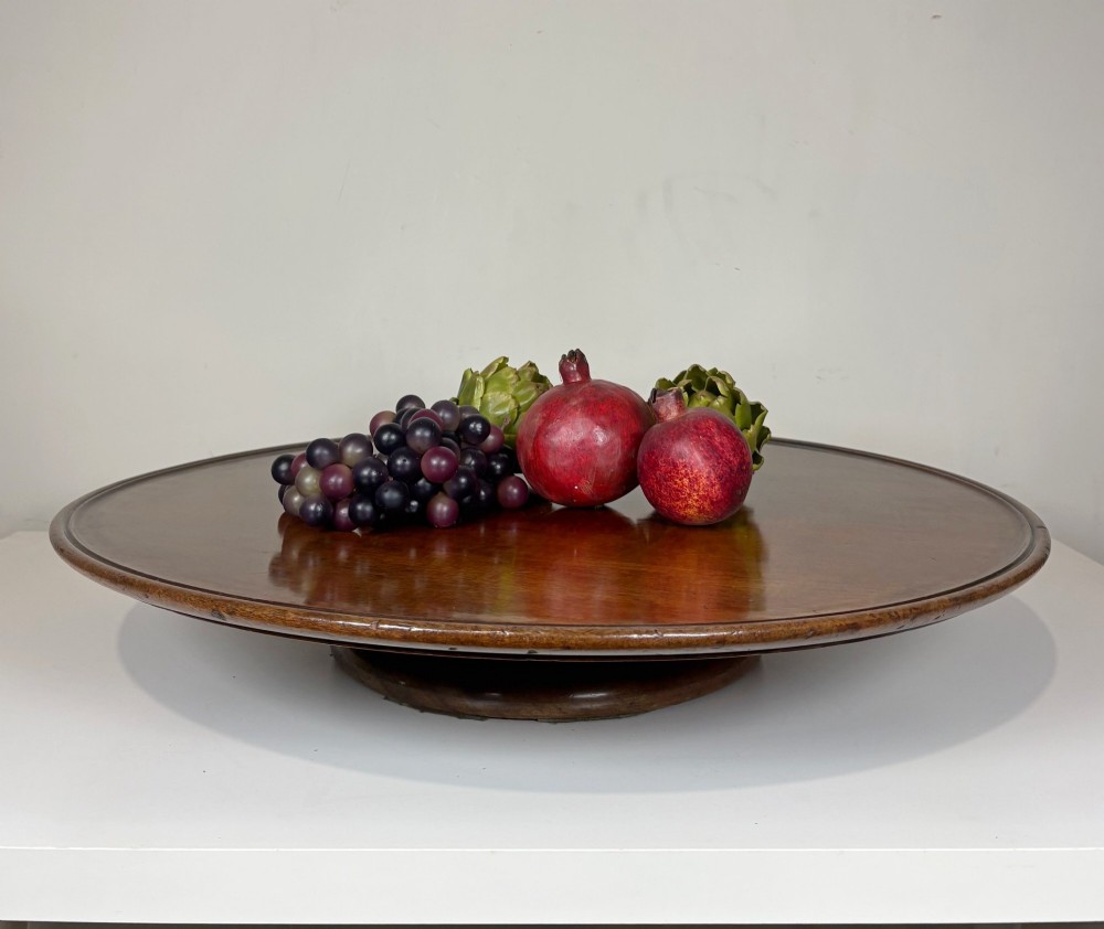 A large circular nineteenth-century mahogany lazy susan featuring a moulded rim and resting on a low pedestal base.
