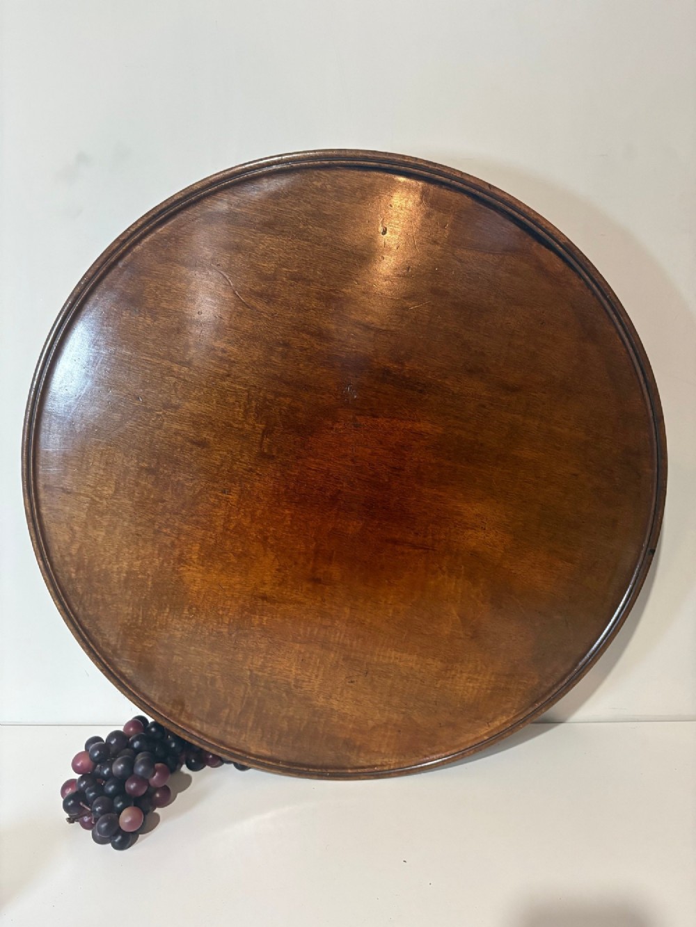 A large circular nineteenth-century mahogany lazy susan featuring a moulded rim and resting on a low pedestal base. View II