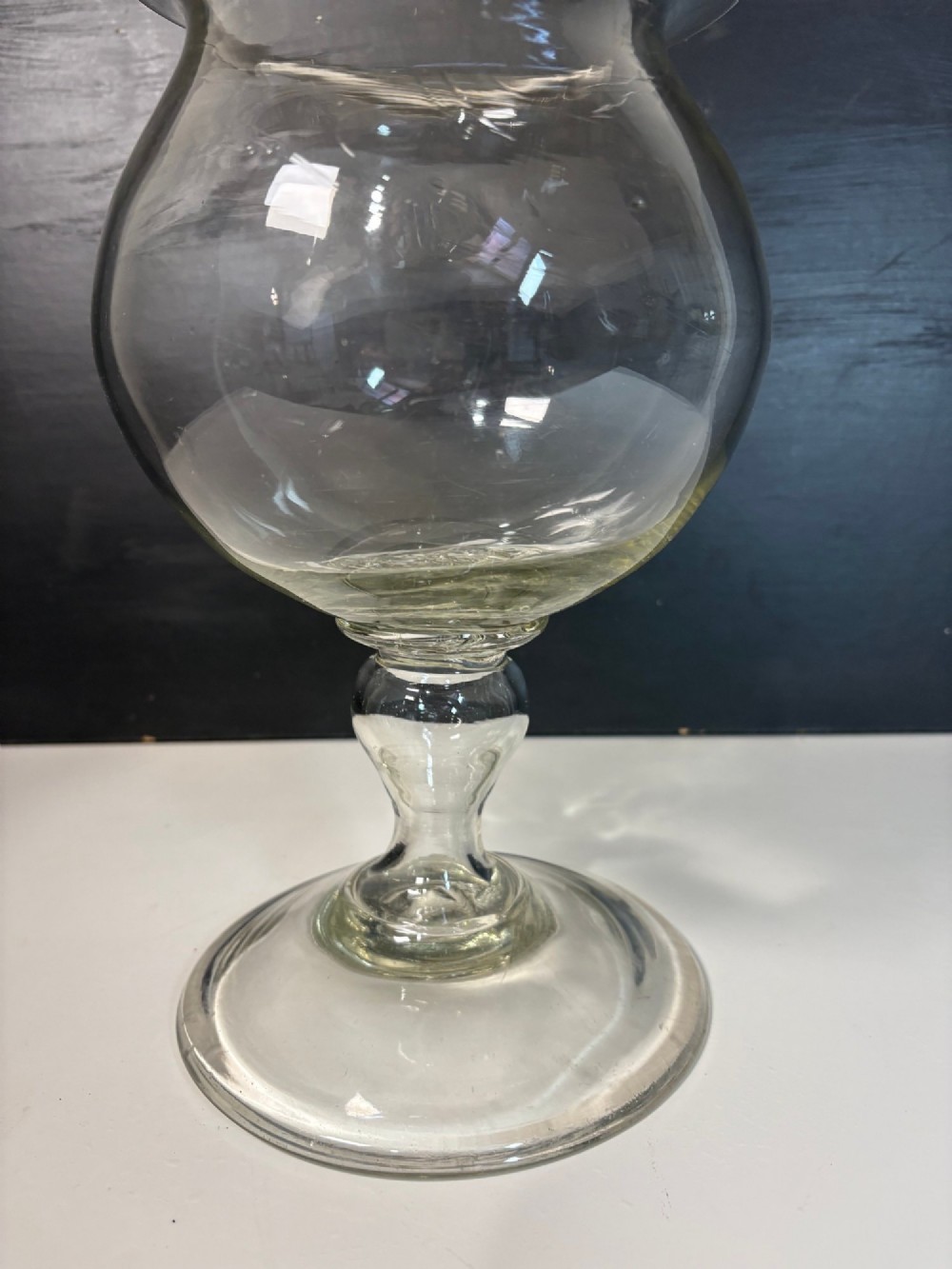 An 18th-century clear hand-blown glass leech jar featuring a wide flared rim, bulbous body, knopped stem, and a wide circular pedestal foot. View III