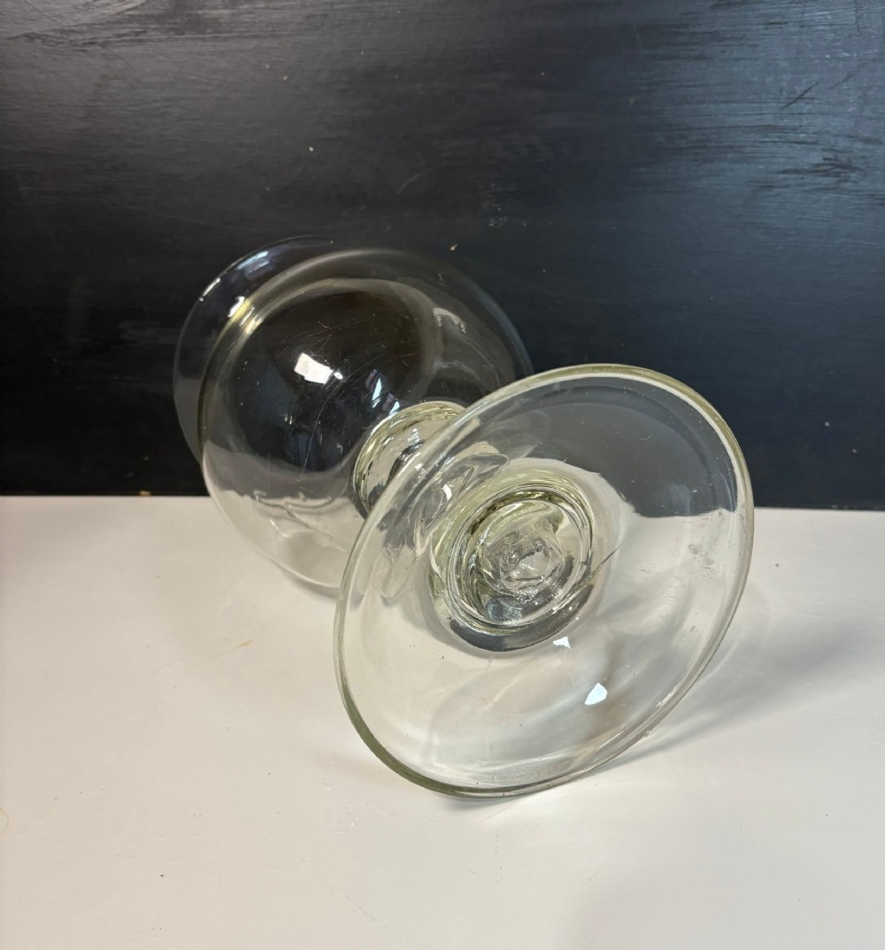 An 18th-century clear hand-blown glass leech jar featuring a wide flared rim, bulbous body, knopped stem, and a wide circular pedestal foot. View V