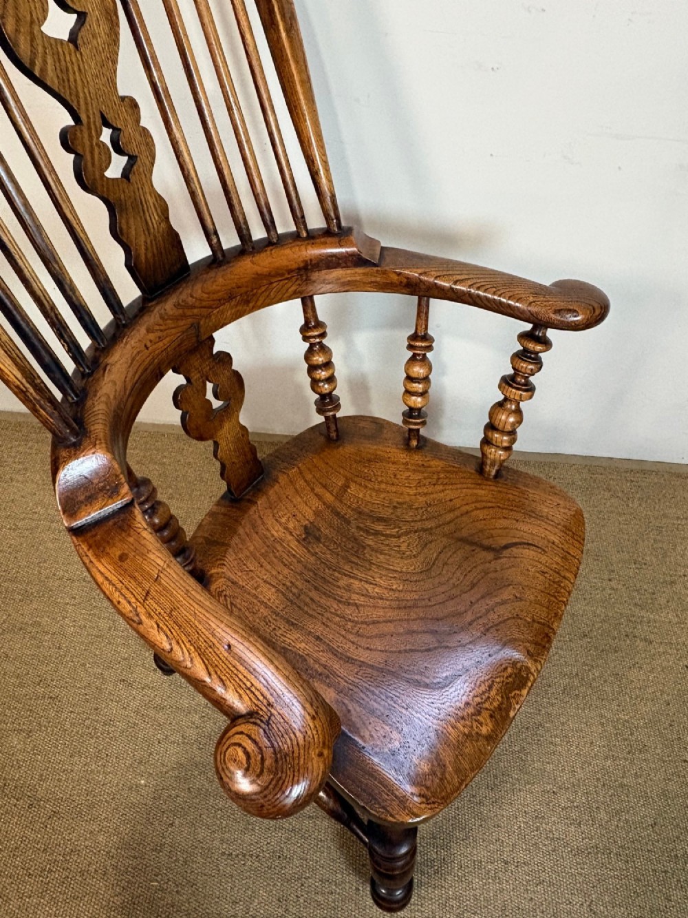 A 19th-century high-back wooden Windsor armchair featuring turned legs, a shaped seat, and a pierced back splat with vertical spindles. View V