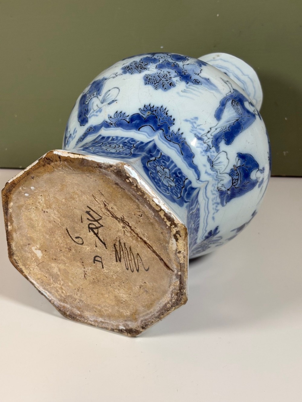 An 18th-century octagonal Delftware vase featuring hand-painted cobalt blue Chinoiserie figures and floral patterns against a white glaze. View V