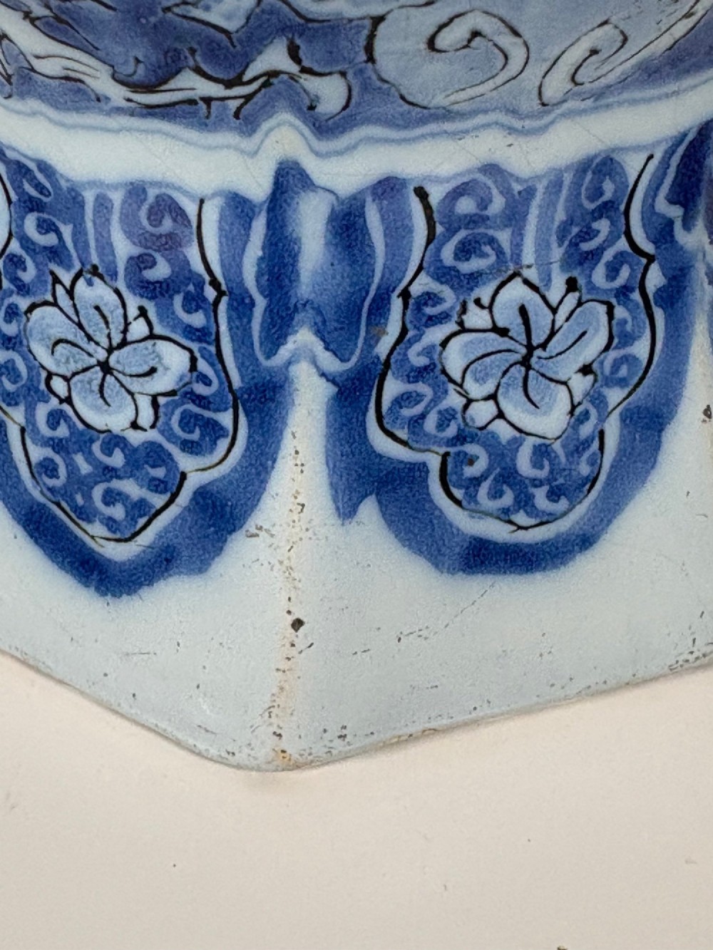 An 18th-century octagonal Delftware vase featuring hand-painted cobalt blue Chinoiserie figures and floral patterns against a white glaze. View VII