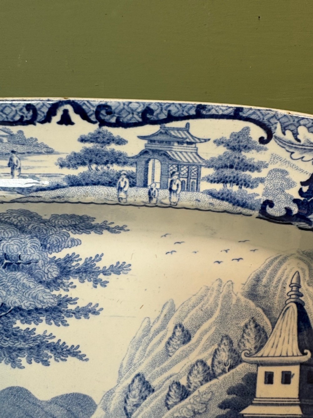 A 19th-century oval blue and white earthenware platter featuring a printed Chinoiserie landscape scene with pagodas, a river boat, and decorative scrollwork borders. View IV
