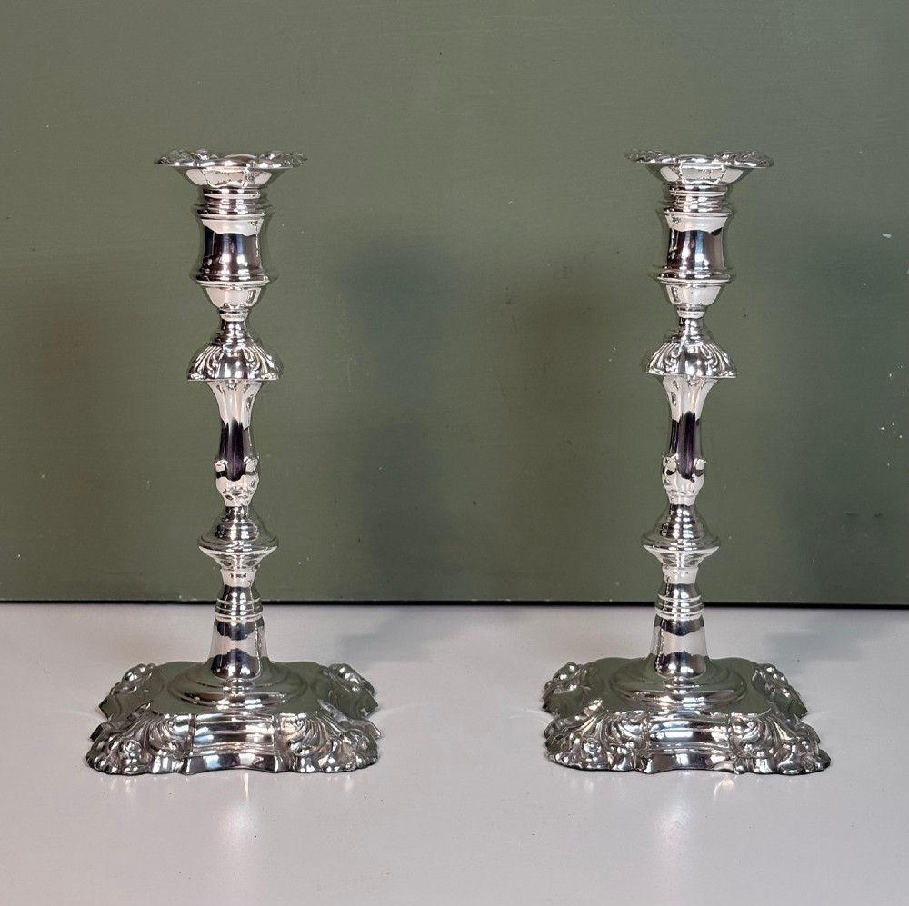 A pair of 19th-century silver candlesticks featuring Rococo style scrollwork, scalloped bases, and knopped stems. View II