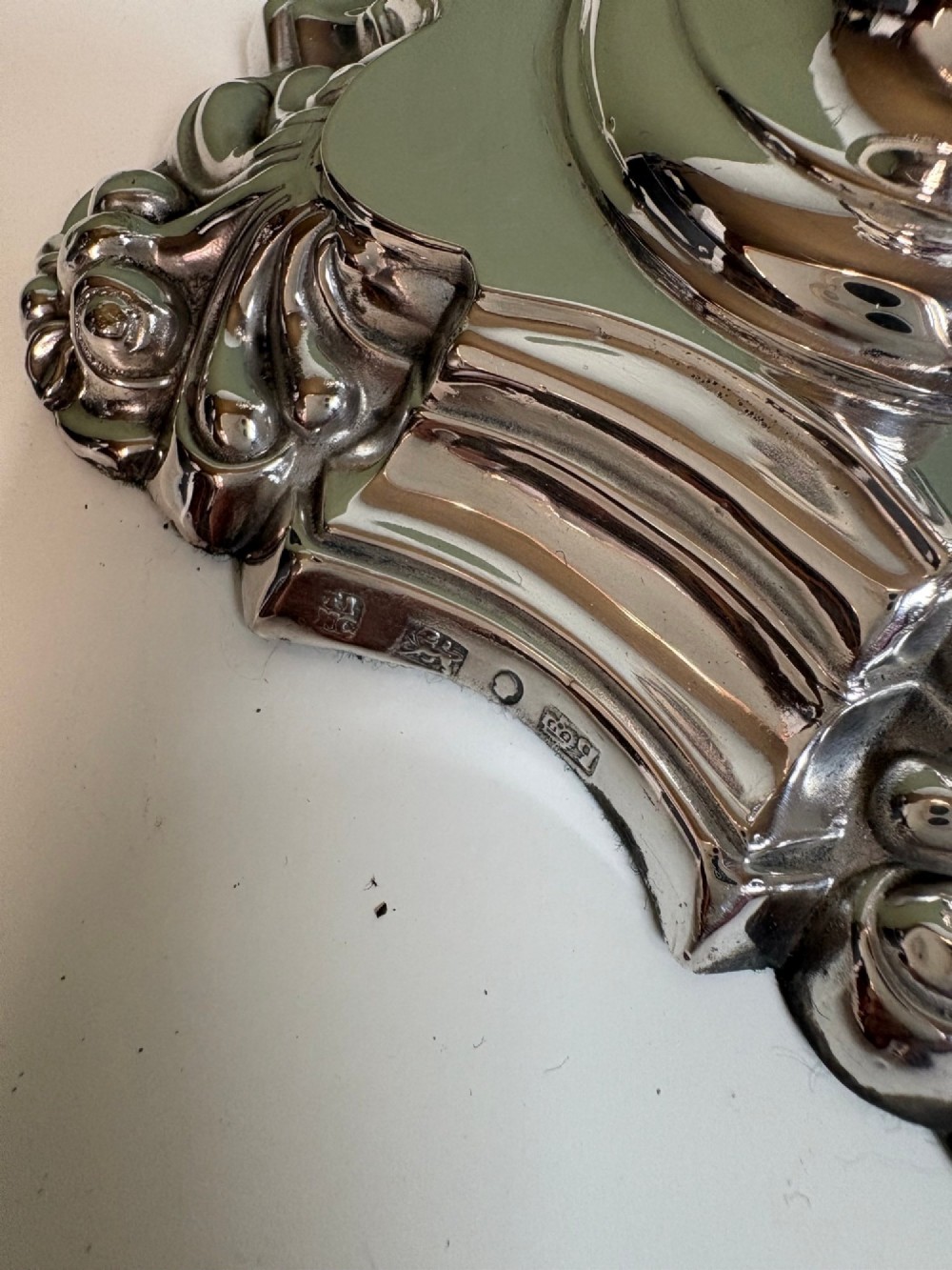 A pair of 19th-century silver candlesticks featuring Rococo style scrollwork, scalloped bases, and knopped stems. View VI