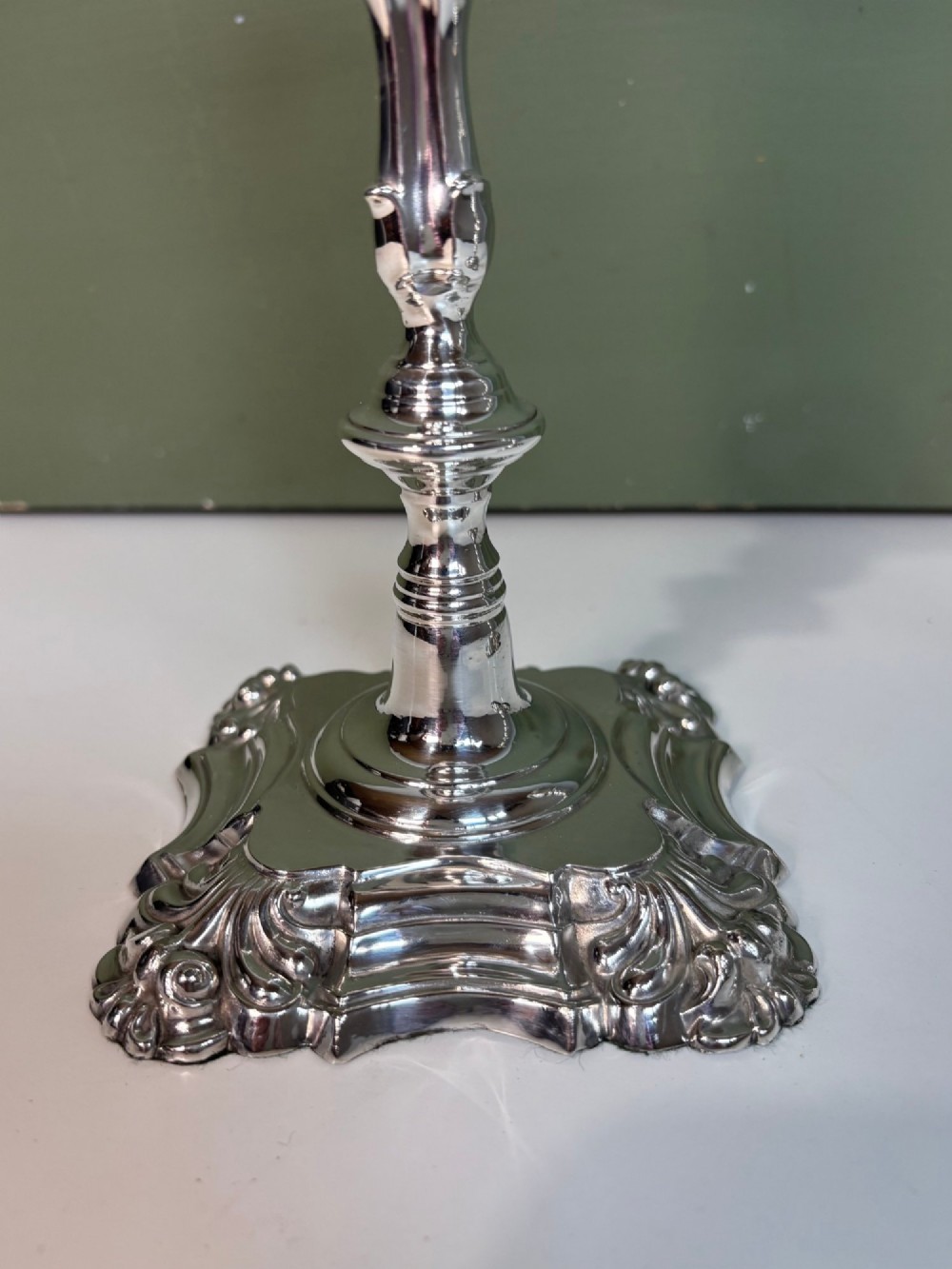 A pair of 19th-century silver candlesticks featuring Rococo style scrollwork, scalloped bases, and knopped stems. View VII