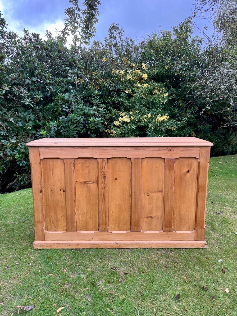 A rectangular antique pine log box featuring vertical timber panelling, a flat top surface, and a solid plinth base. View II