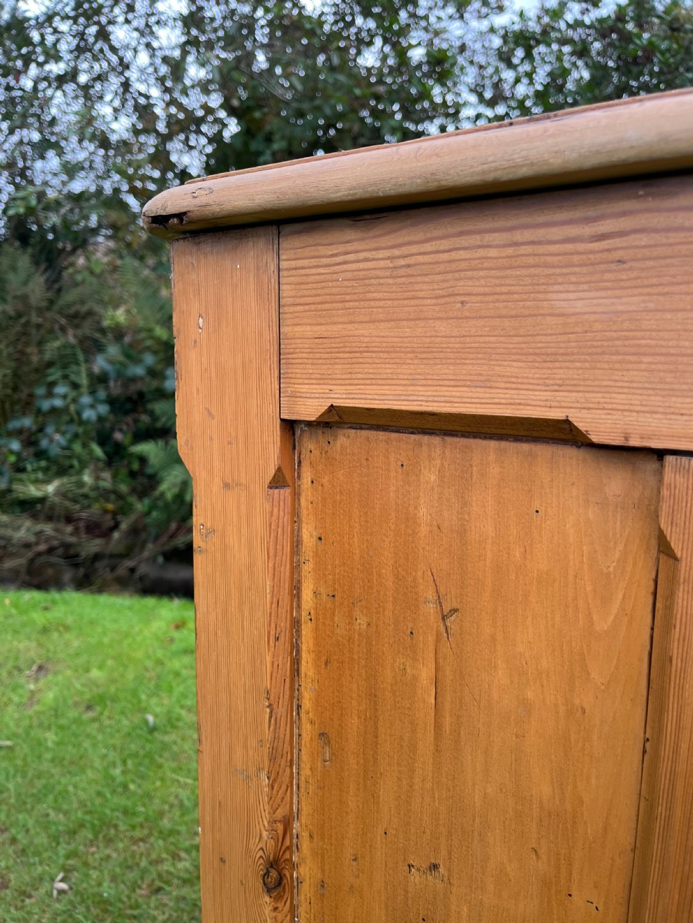 A rectangular antique pine log box featuring vertical timber panelling, a flat top surface, and a solid plinth base. View X