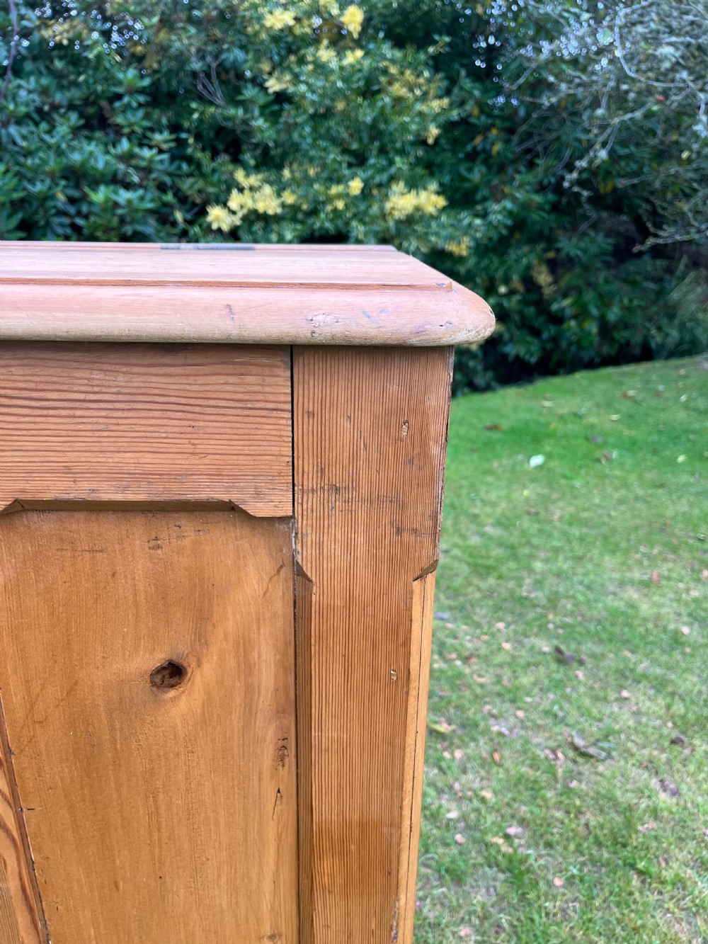 A rectangular antique pine log box featuring vertical timber panelling, a flat top surface, and a solid plinth base. View XIII