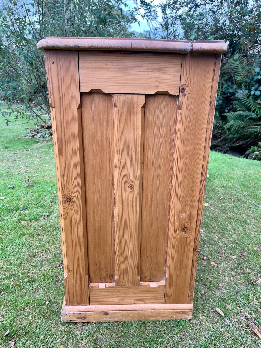 A rectangular antique pine log box featuring vertical timber panelling, a flat top surface, and a solid plinth base. View XV