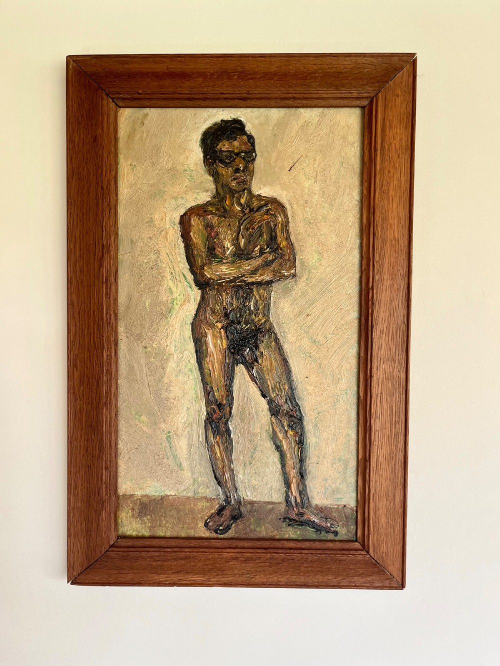 A framed expressionist oil painting depicting a standing male nude figure with crossed arms rendered in thick impasto paint.