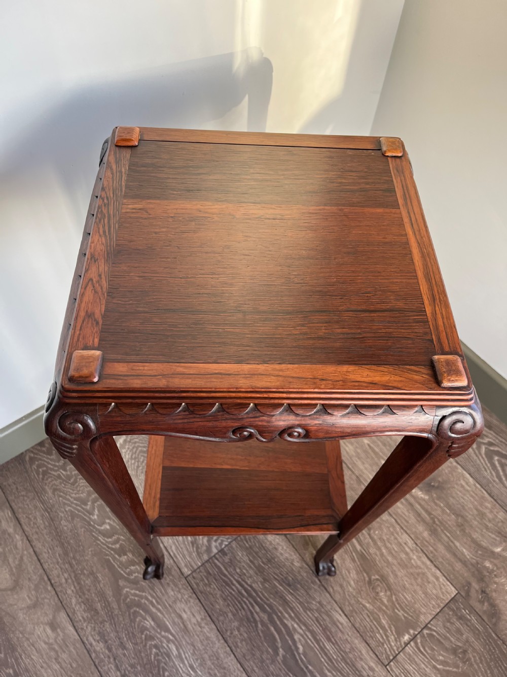 A tall, square antique rosewood lamp table featuring carved aprons, a lower shelf tier, and slender legs ending in carved feet. View II