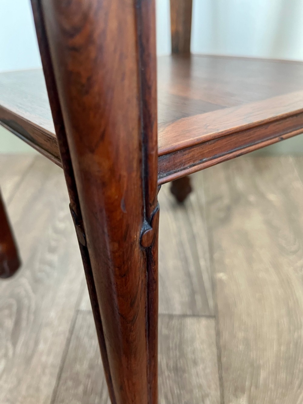 A tall, square antique rosewood lamp table featuring carved aprons, a lower shelf tier, and slender legs ending in carved feet. View IV