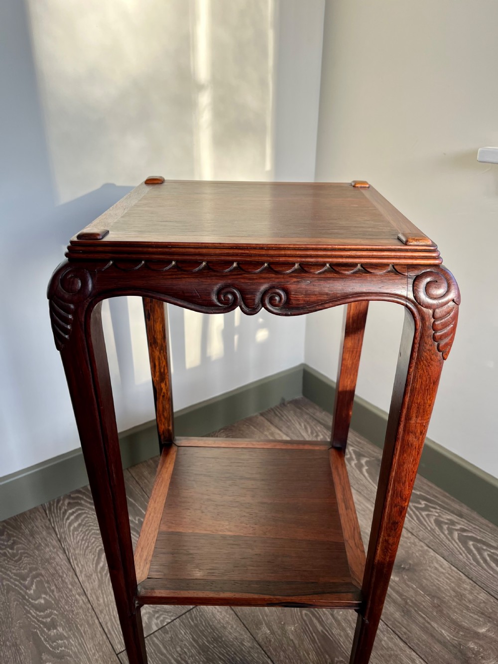 A tall, square antique rosewood lamp table featuring carved aprons, a lower shelf tier, and slender legs ending in carved feet. View IX