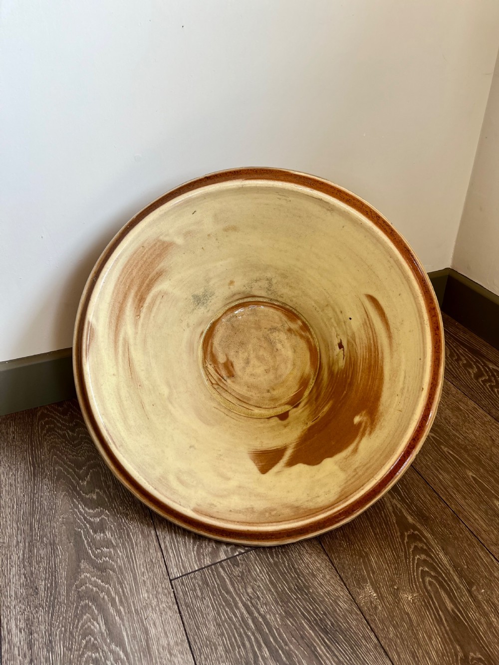 A large flared antique terracotta dairy bowl featuring a pale yellow glazed interior and a rounded rolled rim. View II