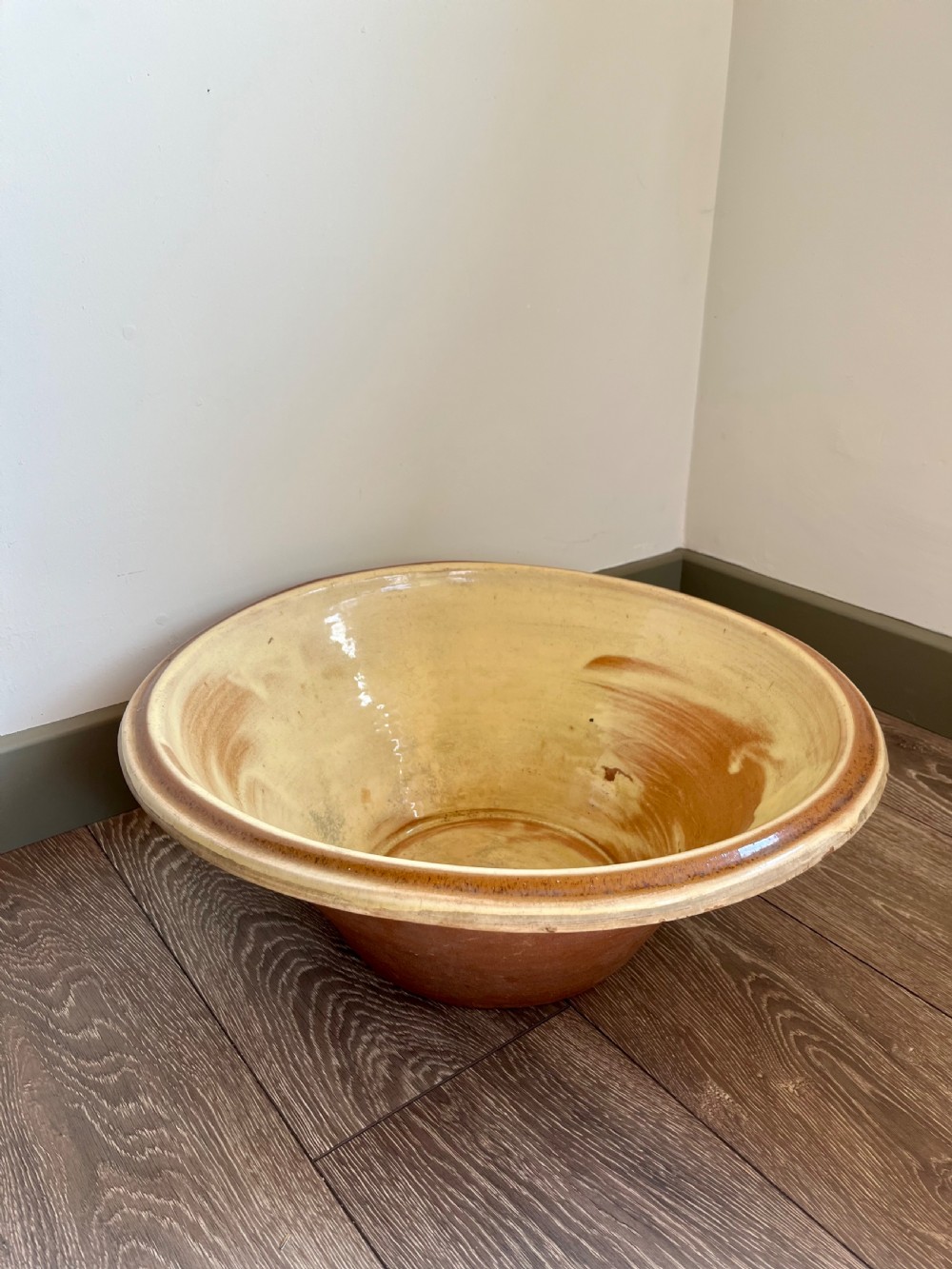 A large flared antique terracotta dairy bowl featuring a pale yellow glazed interior and a rounded rolled rim. View III