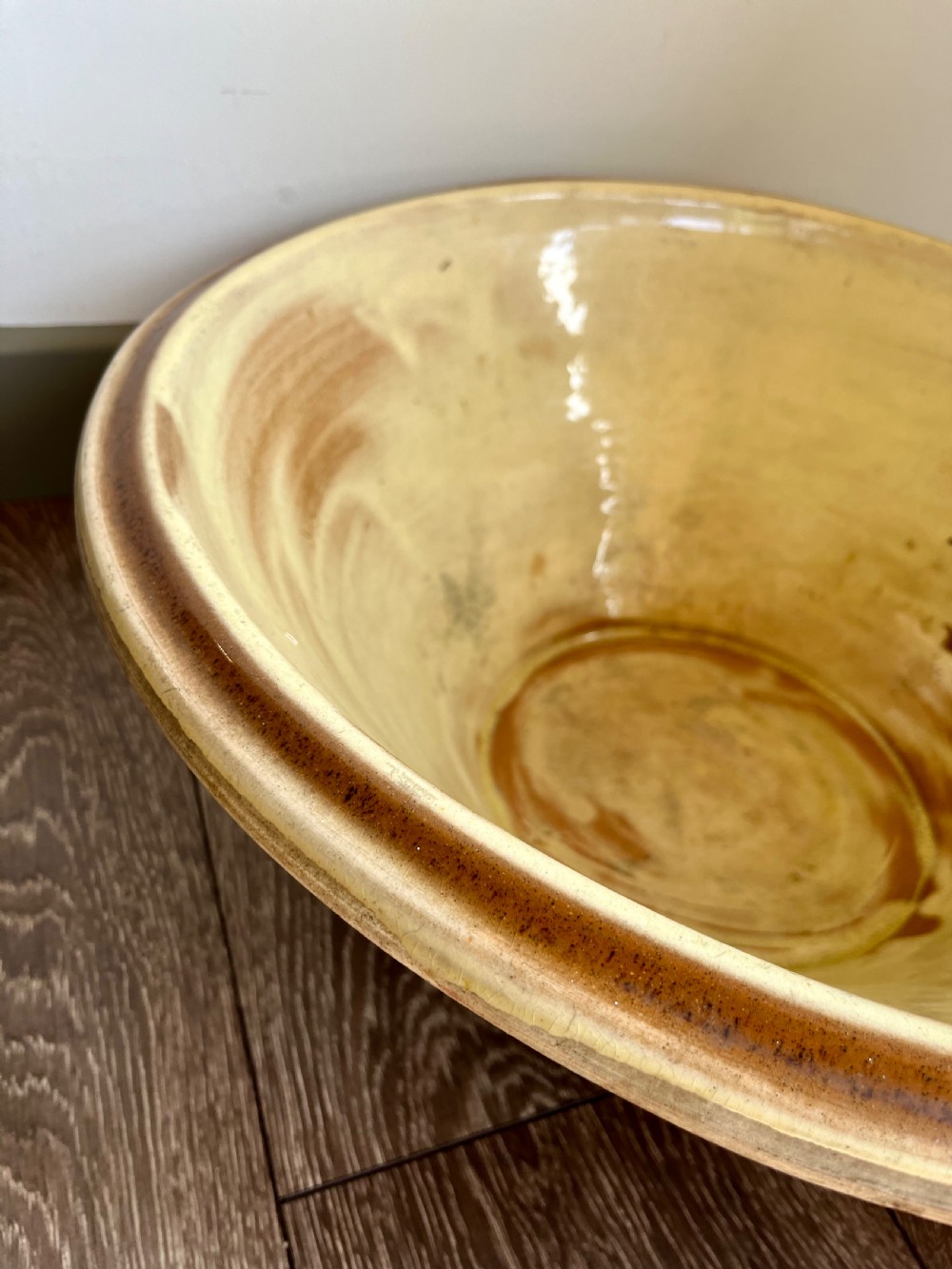 A large flared antique terracotta dairy bowl featuring a pale yellow glazed interior and a rounded rolled rim. View IV