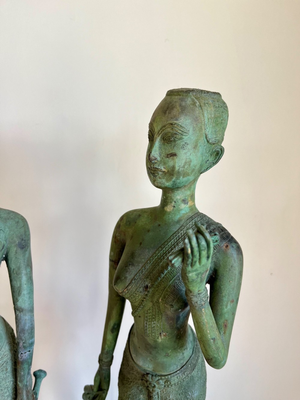 A pair of full-length bronze statues depicting a standing male and female figure with a green verdigris patina, positioned on rounded carved bases. View II