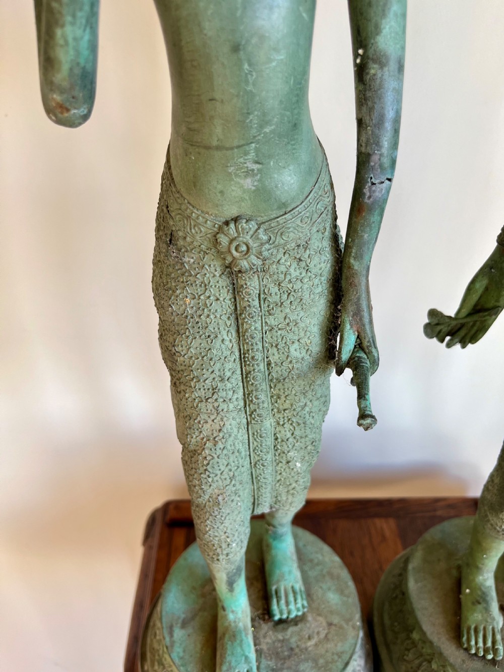 A pair of full-length bronze statues depicting a standing male and female figure with a green verdigris patina, positioned on rounded carved bases. View III