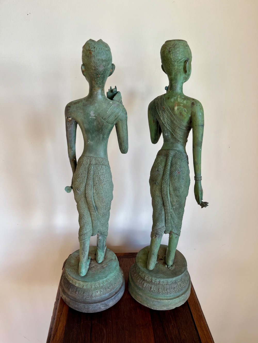 A pair of full-length bronze statues depicting a standing male and female figure with a green verdigris patina, positioned on rounded carved bases. View VIII