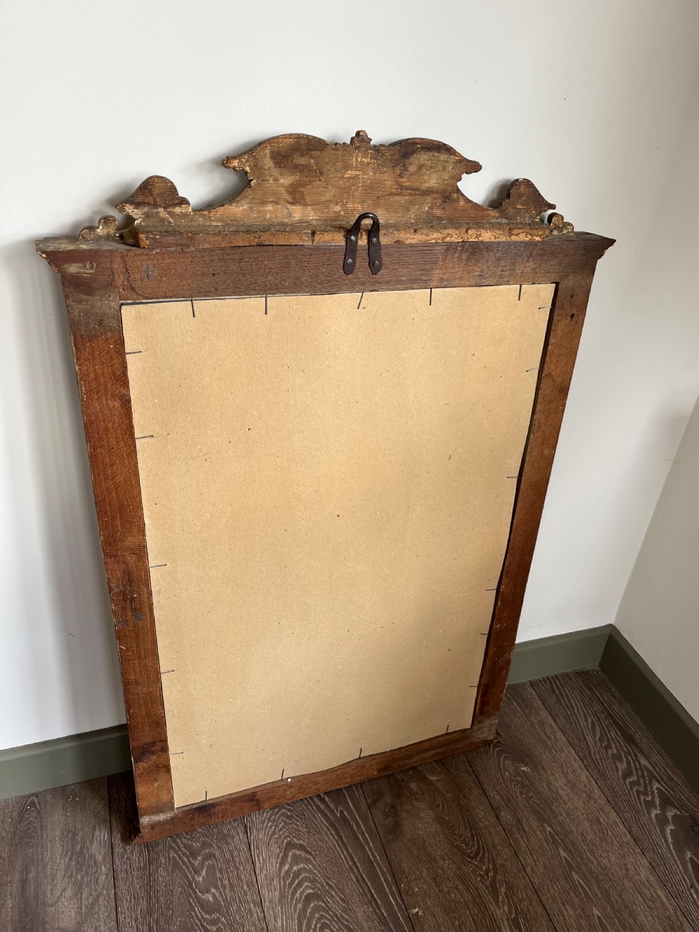 A rectangular painted wooden wall mirror featuring a carved scrolled pediment, an arched inner frame, and painted foliage motifs on a green background. View IX