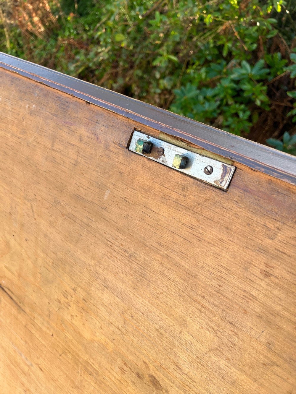 A rectangular dark reddish-brown pine storage chest with a hinged lid, painted panel border detail, and iron side handles. View XIII
