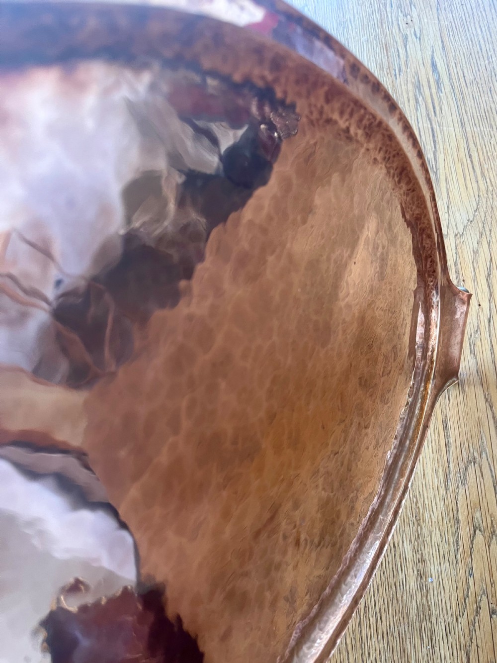 A large oval hand-hammered copper serving tray featuring integrated raised handles at both ends. View IV
