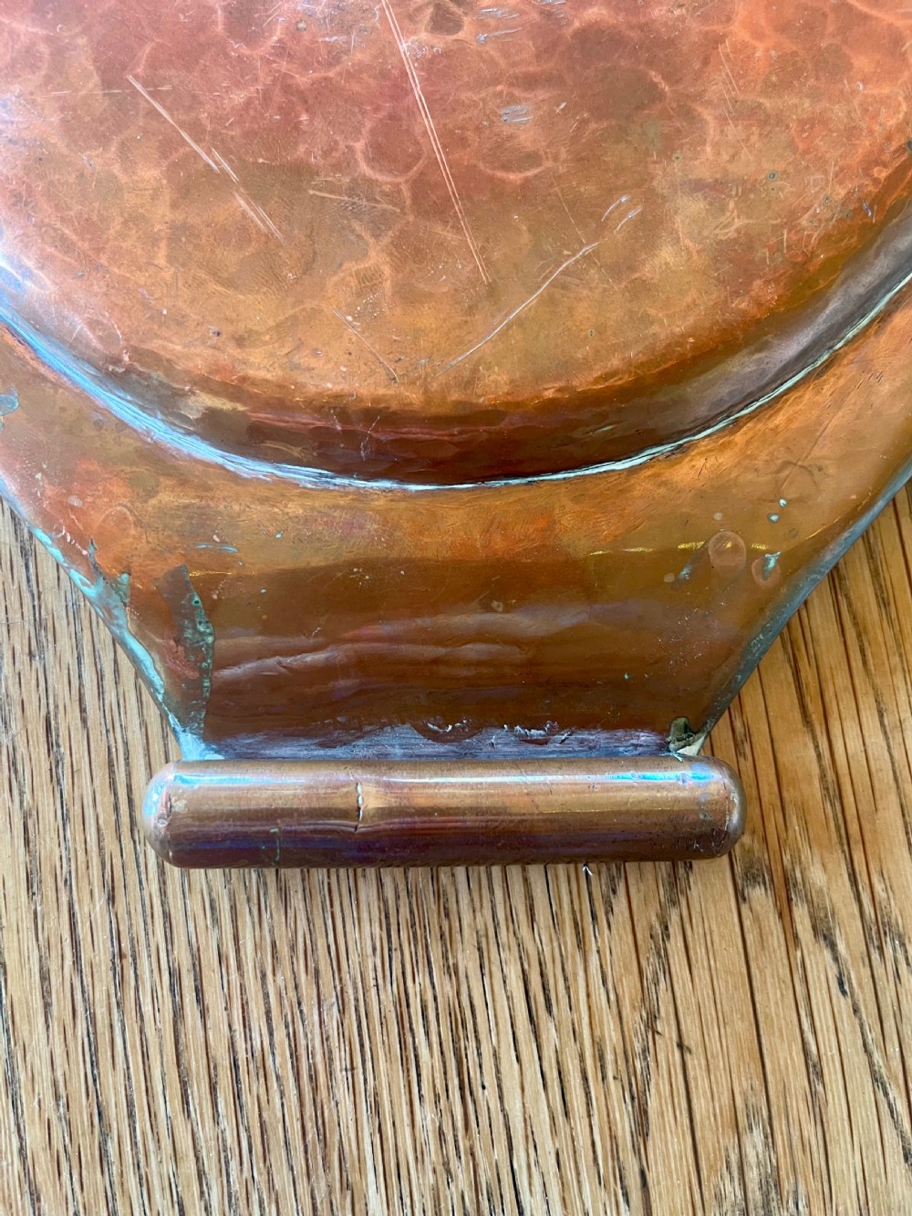 A large oval hand-hammered copper serving tray featuring integrated raised handles at both ends. View VI