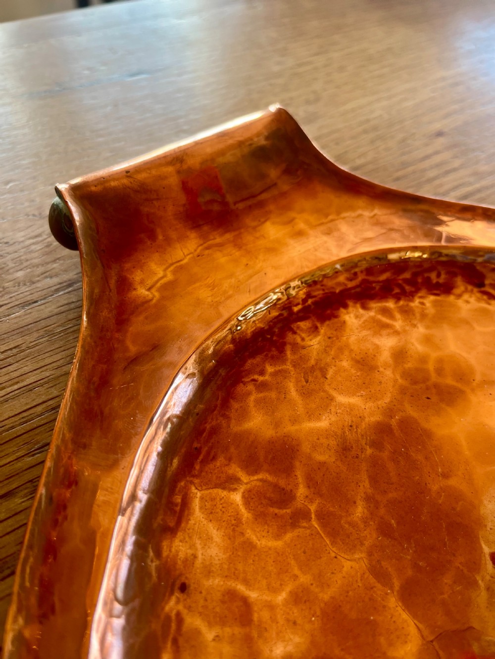 A large oval hand-hammered copper serving tray featuring integrated raised handles at both ends. View VIII