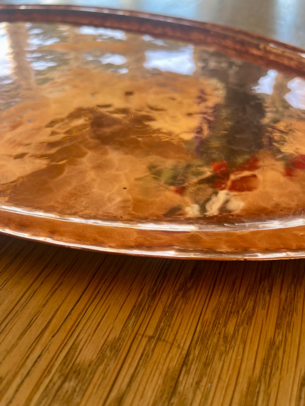 A large oval hand-hammered copper serving tray featuring integrated raised handles at both ends. View X