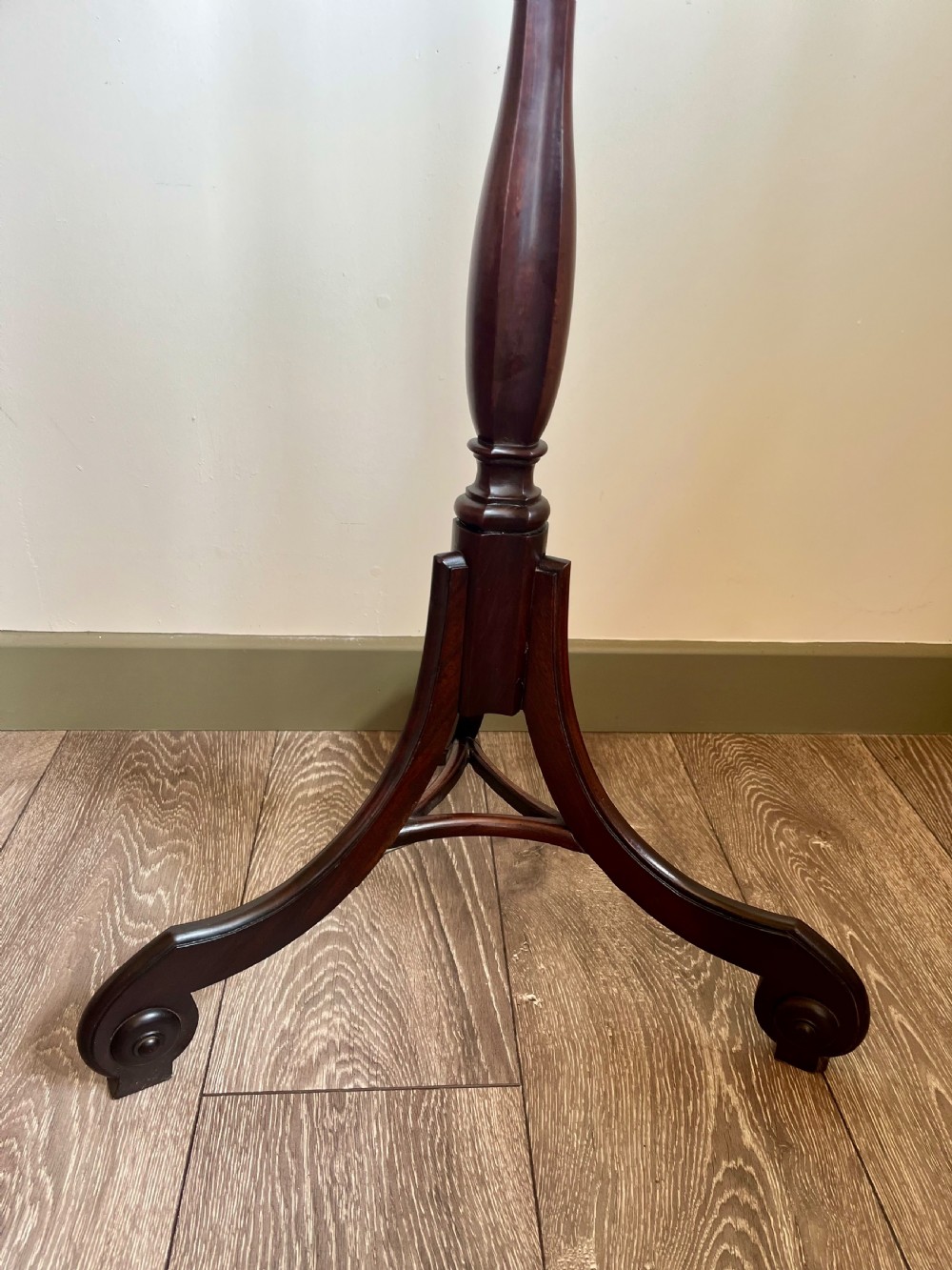 A dark mahogany torchere plant stand featuring a scalloped circular top, a turned column shaft, and a tripod base with scrolled feet. View III