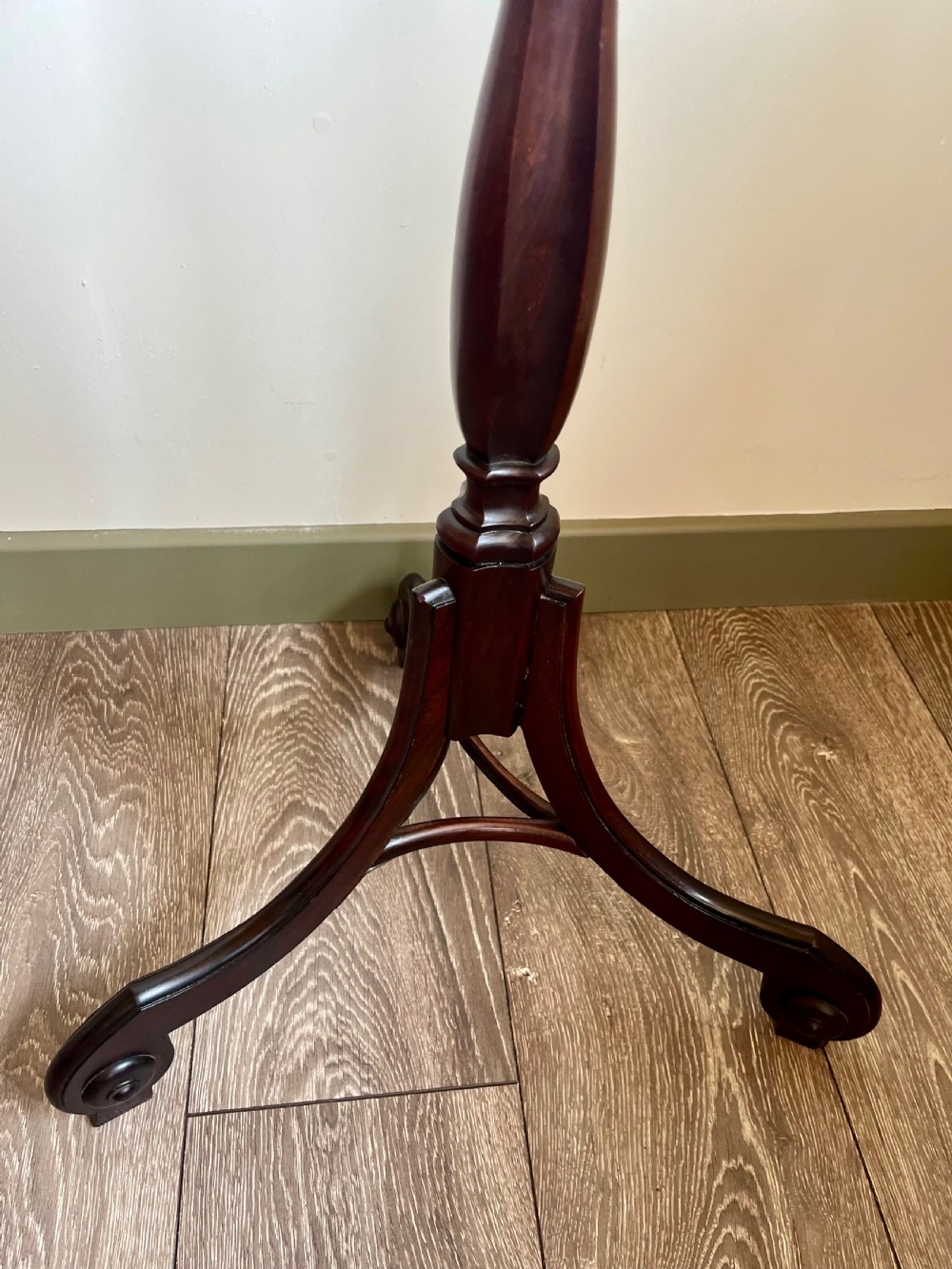 A dark mahogany torchere plant stand featuring a scalloped circular top, a turned column shaft, and a tripod base with scrolled feet. View IV