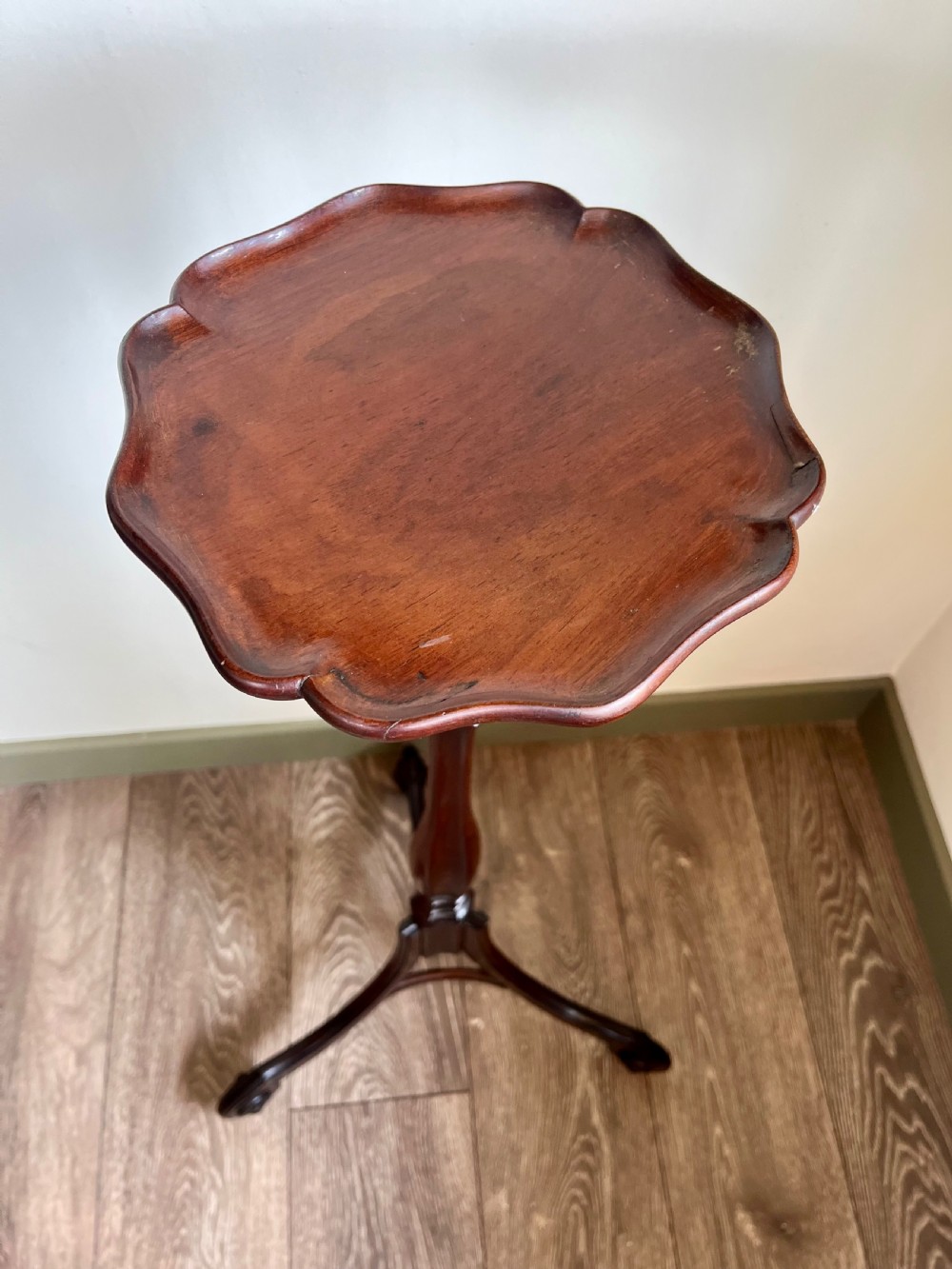 A dark mahogany torchere plant stand featuring a scalloped circular top, a turned column shaft, and a tripod base with scrolled feet. View VII