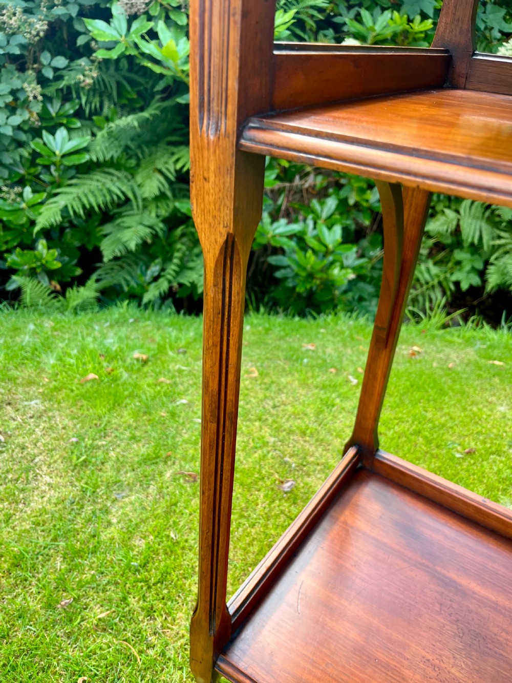 A three-tiered walnut wooden console table featuring a shaped gallery top, carved aprons, and slender tapered legs. View III