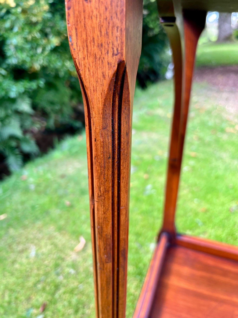 A three-tiered walnut wooden console table featuring a shaped gallery top, carved aprons, and slender tapered legs. View IX