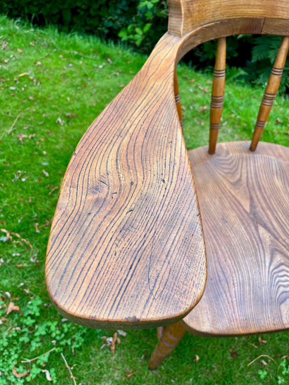 A pair of warm brown wooden smokers bow armchairs with turned spindles, contoured saddle seats, and turned legs. View III