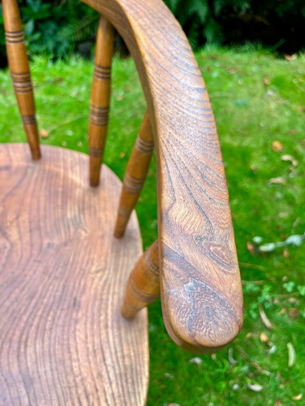 A pair of warm brown wooden smokers bow armchairs with turned spindles, contoured saddle seats, and turned legs. View VI