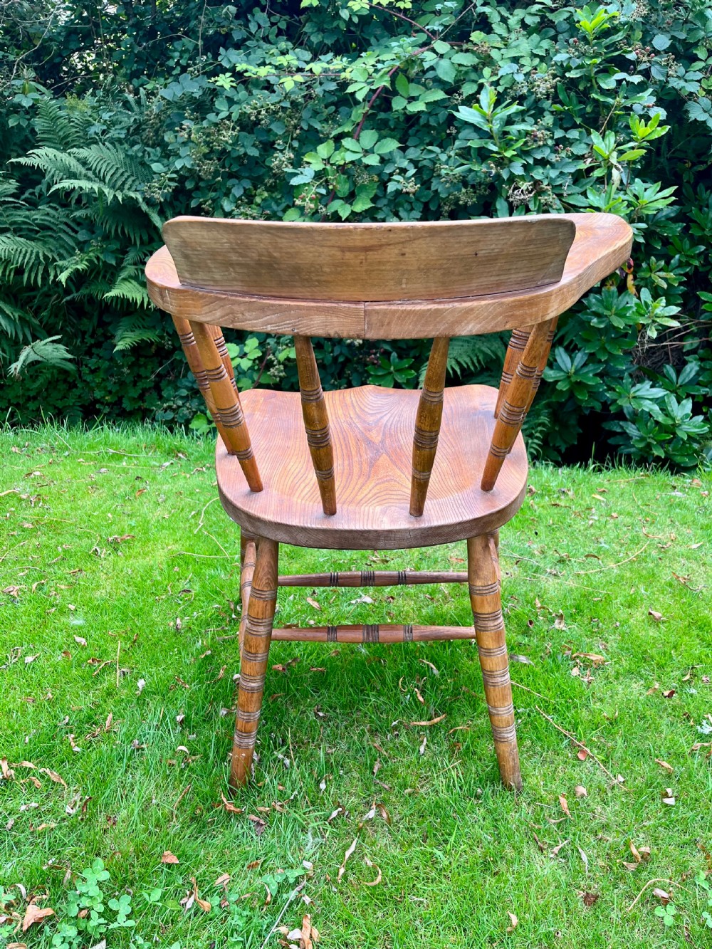 A pair of warm brown wooden smokers bow armchairs with turned spindles, contoured saddle seats, and turned legs. View VII