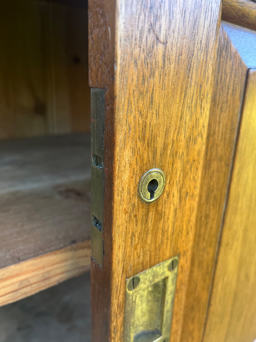A two-part warm brown mahogany campaign cabinet featuring four panelled sliding doors with flush-fitting brass pull handles. View XII