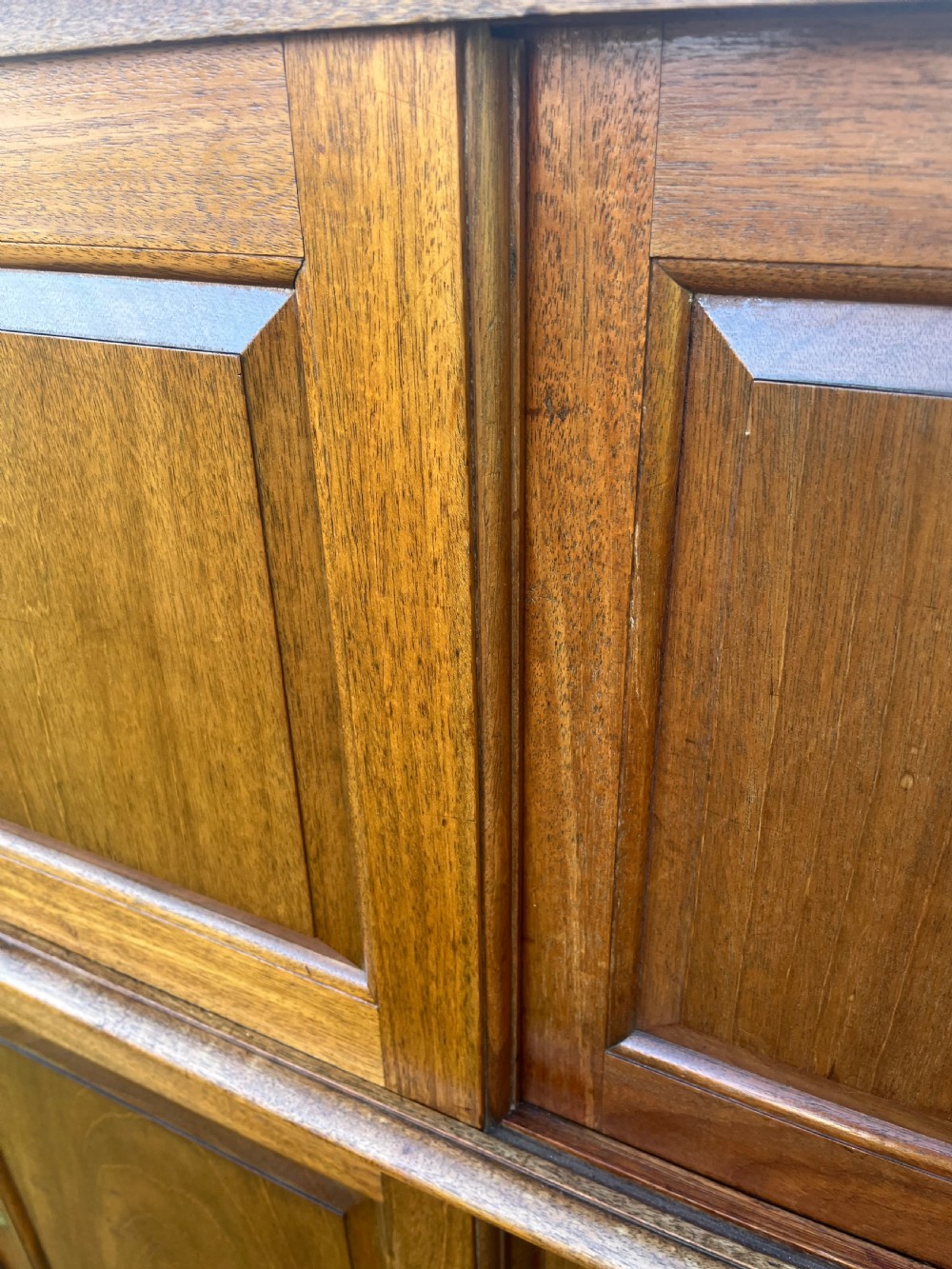 A two-part warm brown mahogany campaign cabinet featuring four panelled sliding doors with flush-fitting brass pull handles. View XIII