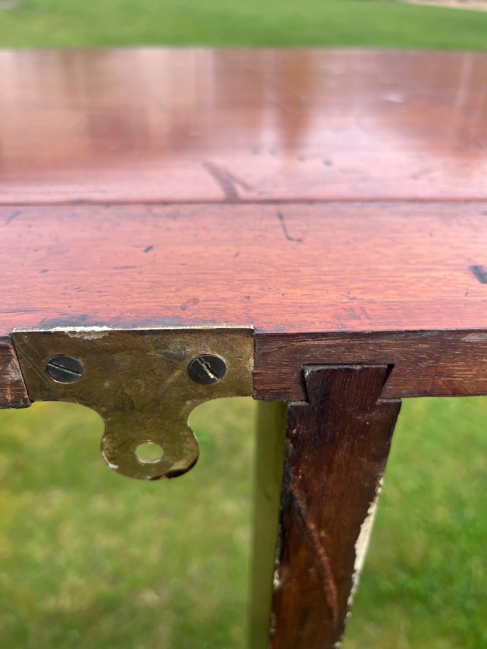 A long, narrow antique wooden butlers console table with a polished warm brown finish, rounded corners, and a collapsible trestle leg frame. View VII